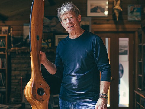  John Scurlock holds a cherry wood propeller made by his friend Ted Hendrickson. "I saw it one day in his shop and thought it was a work of art, he sold it to me for $300 and it's been hanging on my living room wall ever since," John says.